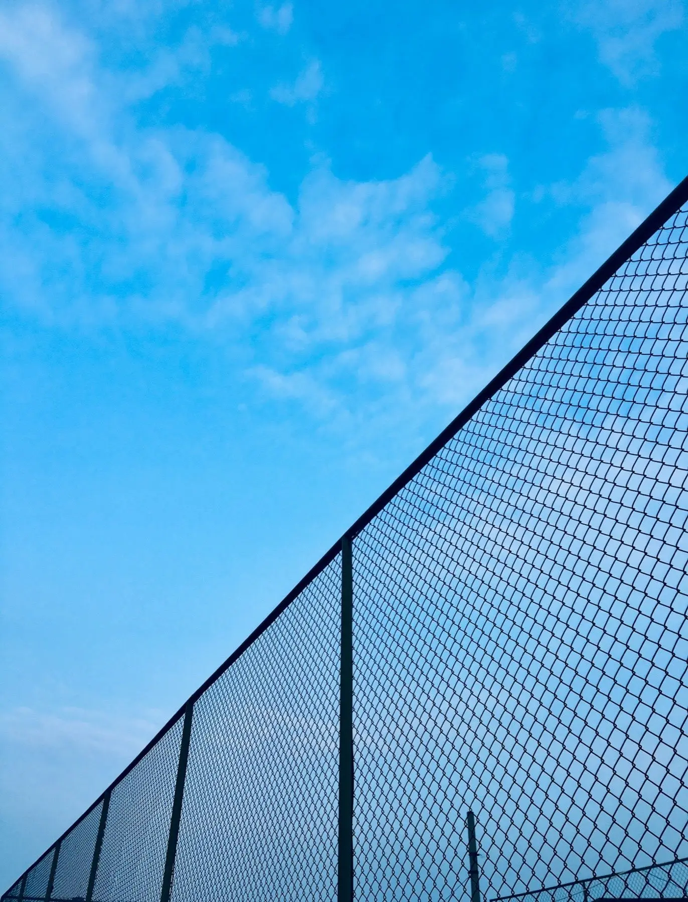 Chain-link fence against a clear blue sky
