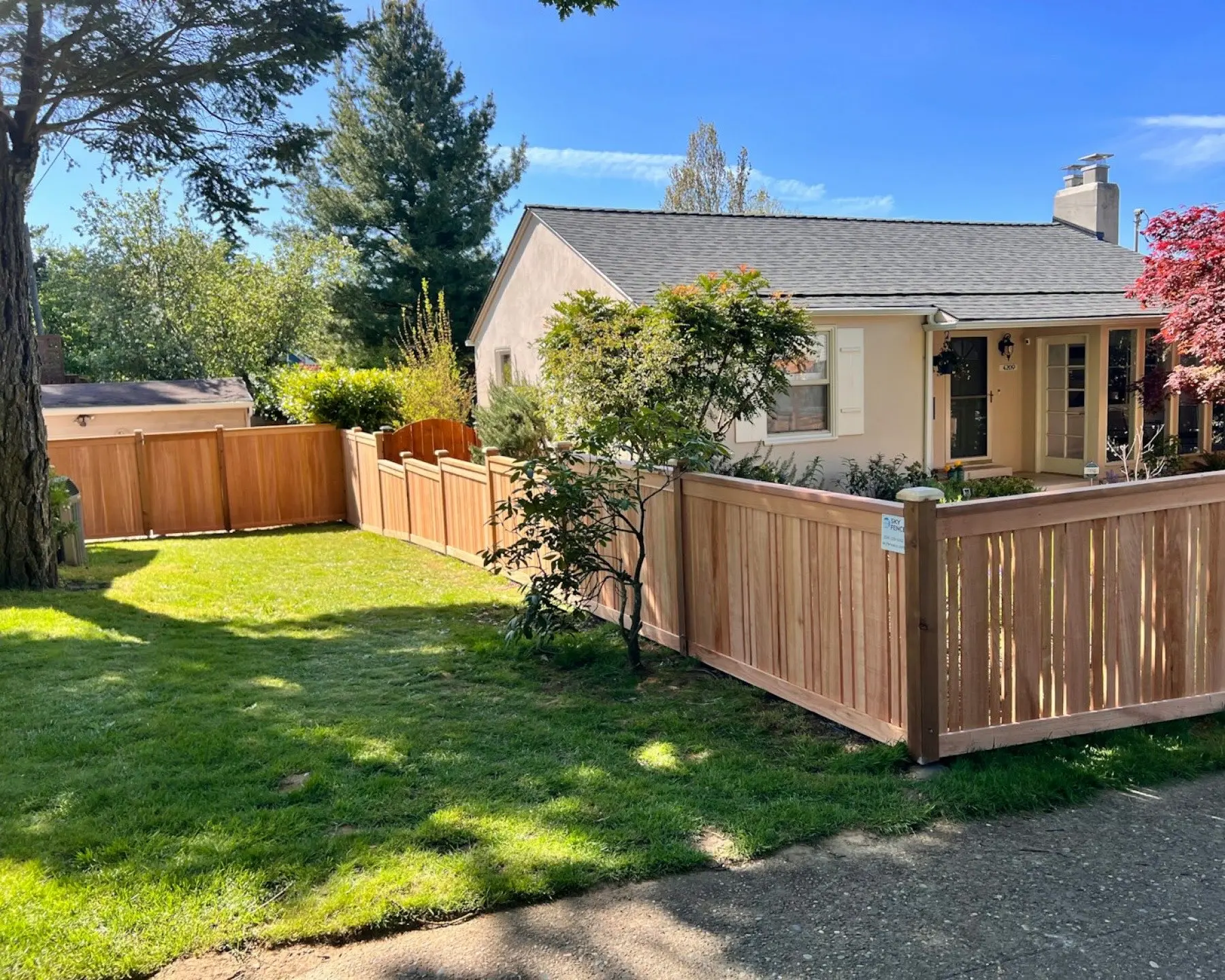 Front yard of a house with a natural wood fence