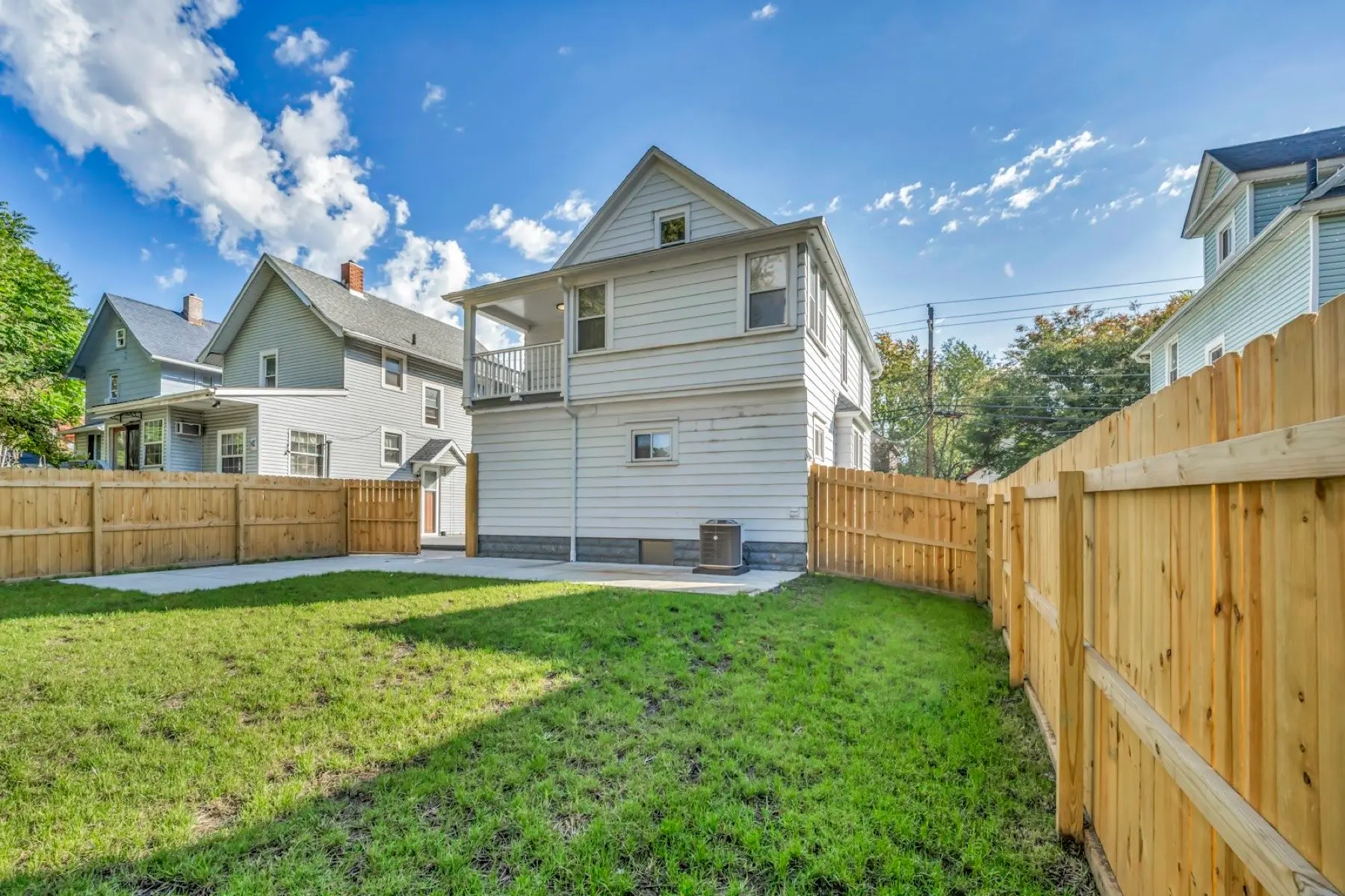 New wood privacy fence enclosing the backyard of a two-storey house